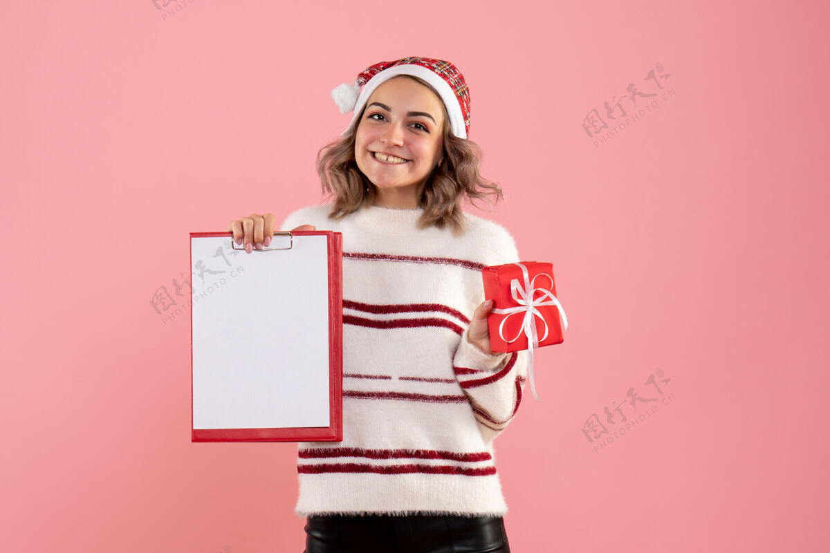 漂亮正面图年轻女性手持圣诞礼物和纸条可爱女人肖像