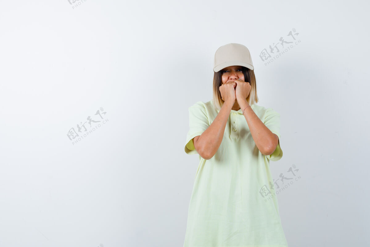 成人年轻的女士穿着t恤 戴着帽子 站在恐惧的姿势 看起来很紧张 正面视图新鲜皮肤美容
