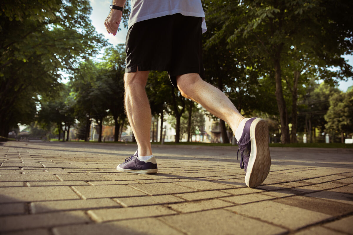 训练高级男子在城市街道上跑步穿着运动鞋的腿部特写镜头高加索男模在夏天的早晨慢跑和有氧训练健康的生活方式 运动 活动理念养老金老年人户外