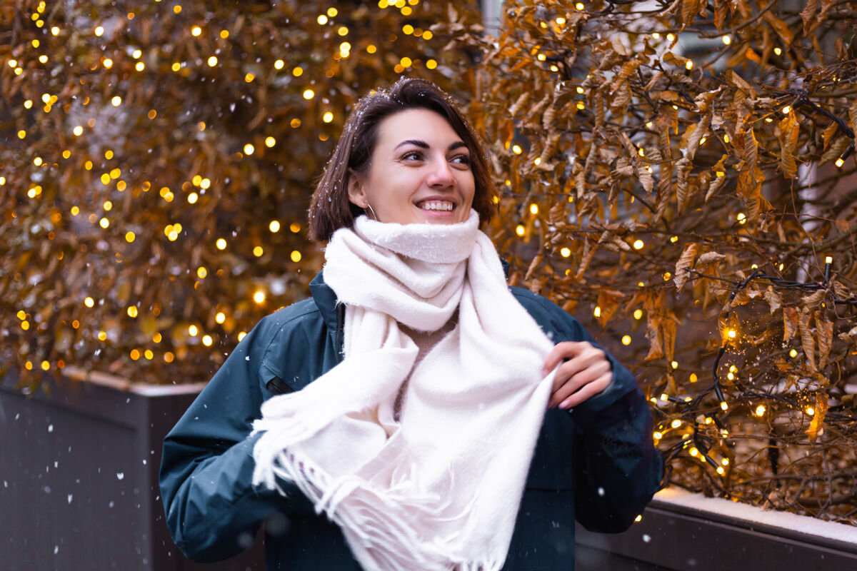 温暖的衣服高加索快乐微笑的女人享受着雪和冬天 戴着温暖的围巾年轻街道情感