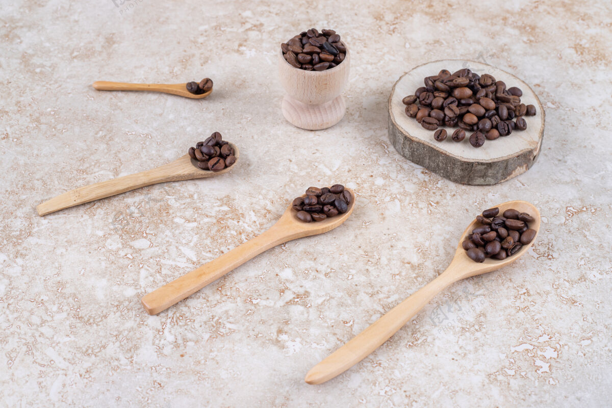 杯子咖啡豆放在勺子上 一块木头和一个小杯咖啡豆木头咖啡