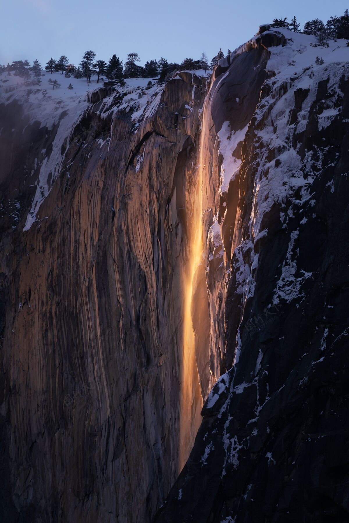 树叶日落时约塞米蒂火焰瀑布的垂直镜头光湖泊瀑布