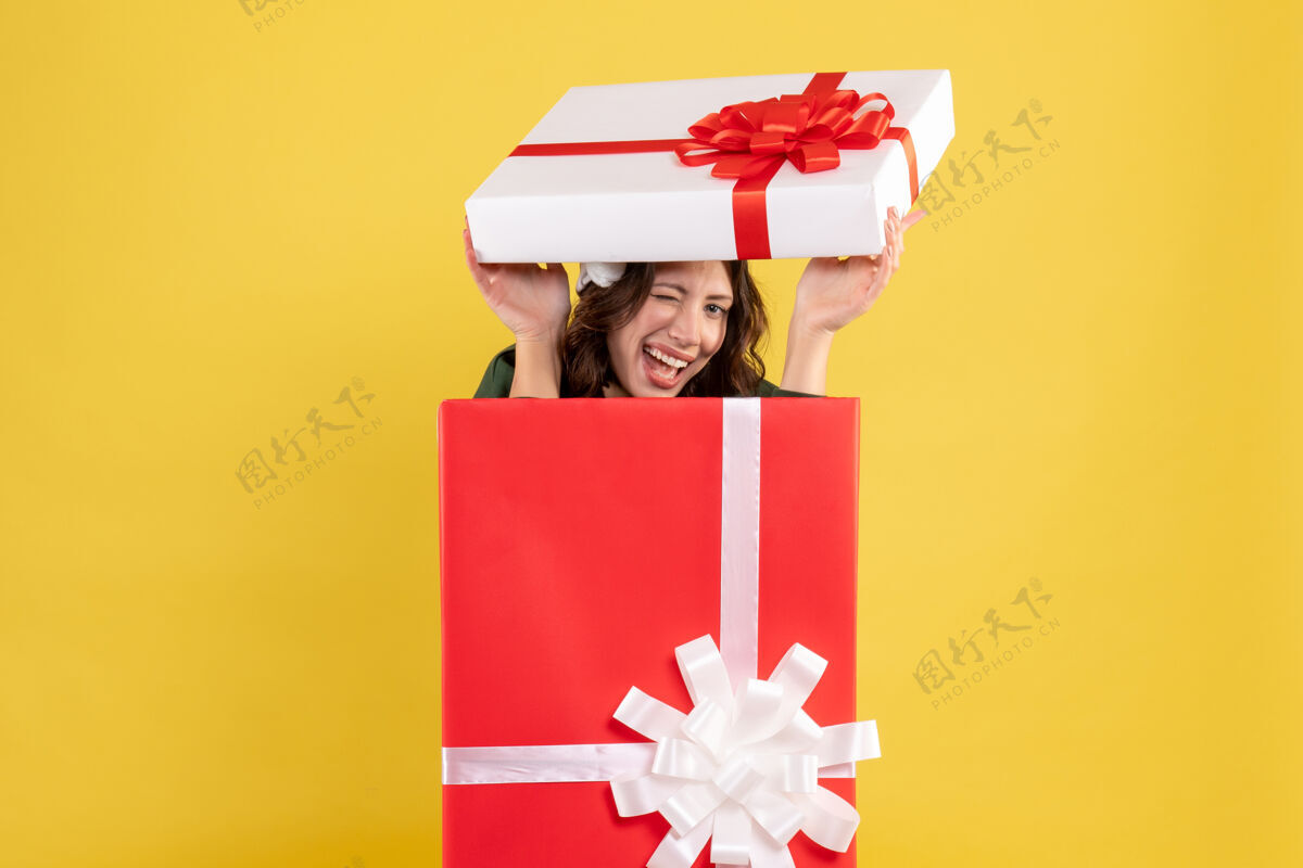 礼物前视图年轻女性躲在黄色盒子里颜色惊喜卖家