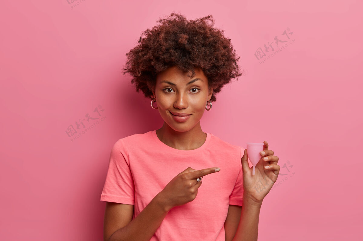 月保护女性卫生美国黑人妇女指着可重复使用的月经杯 展示月经产品 最好的保护方式 好的替代品 隔离在粉红色的墙上生态显示出血