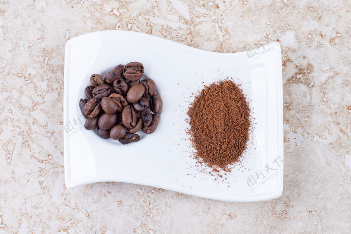 拼盘把咖啡豆和磨碎的咖啡粉放在一个漂亮的盘子里美味粉末研磨