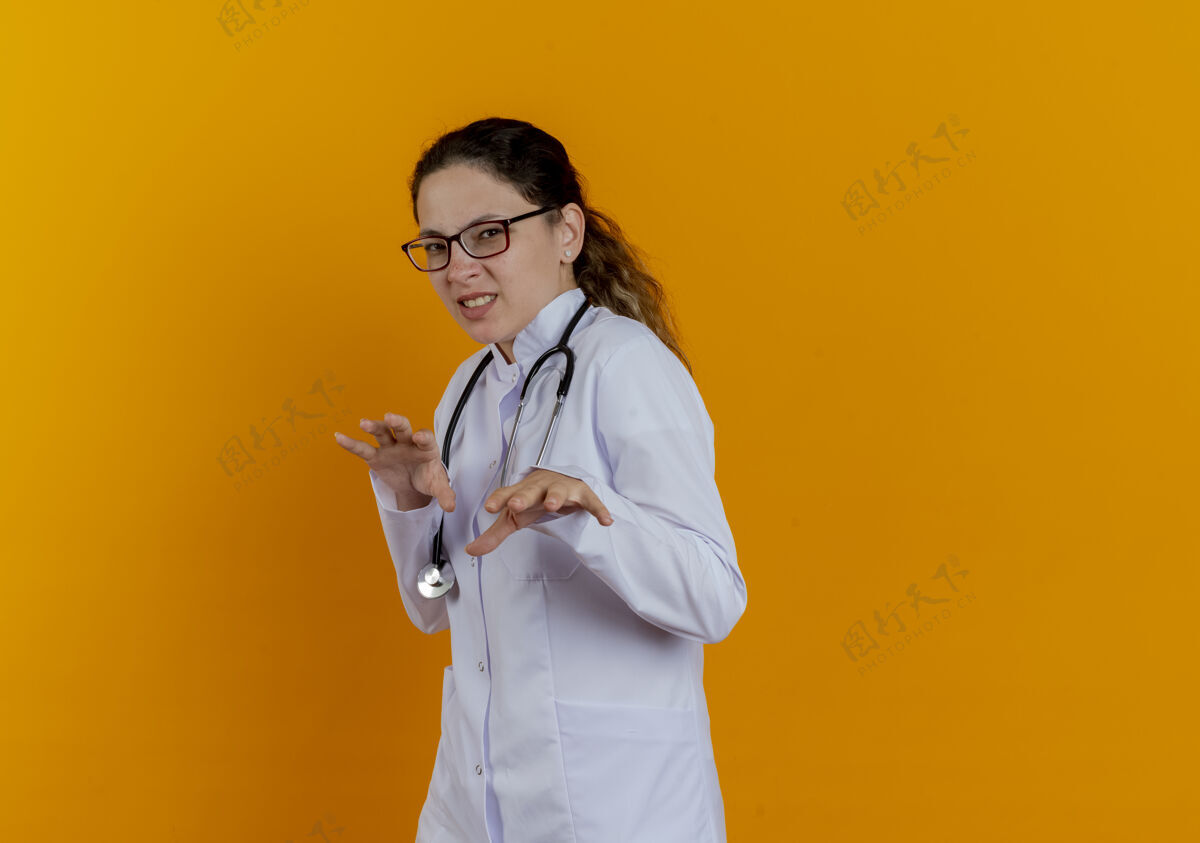 人神经质的年轻女医生 穿着医用长袍 戴着听诊器 戴着隔离眼镜女士成人医生