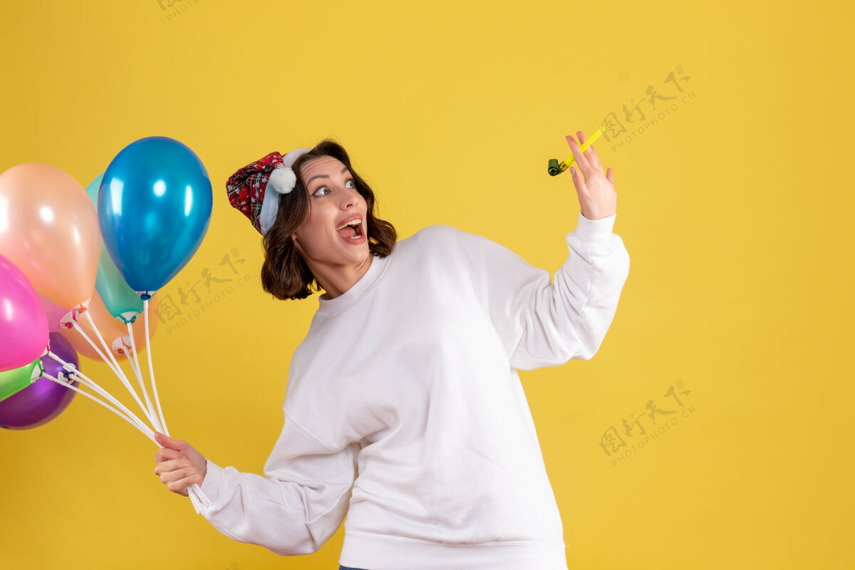 女人正面图年轻女性手持黄色气球举行男人人