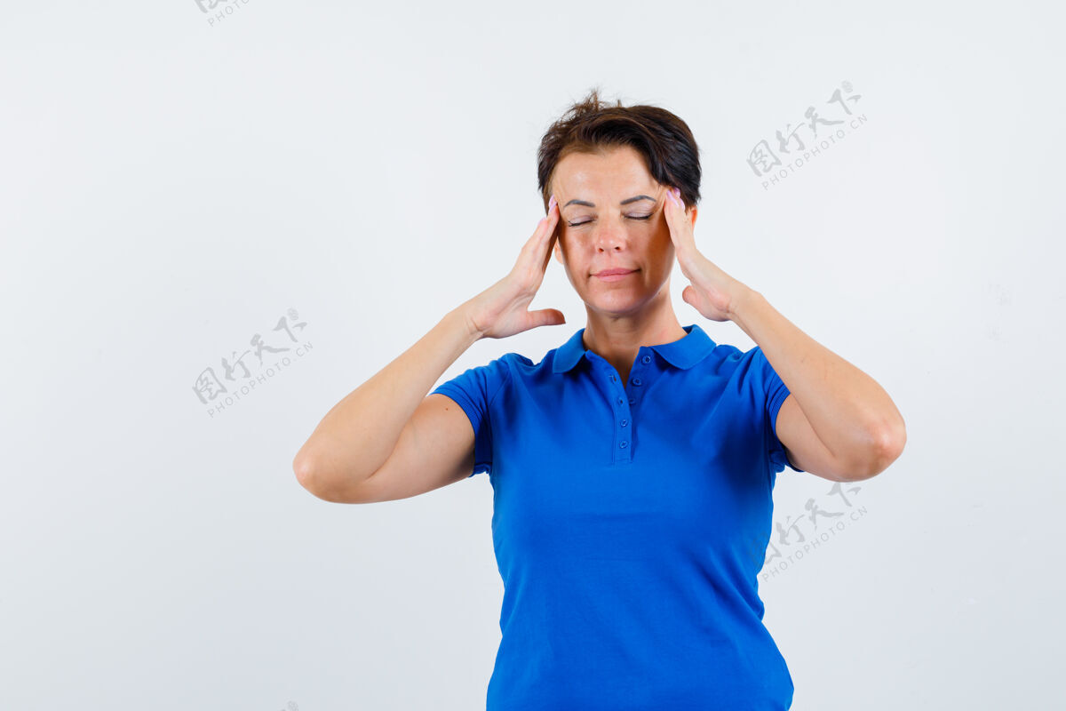 太阳穴成熟的女人穿着蓝色t恤揉着她的太阳穴 看起来很放松前视图健康柔软皮肤护理