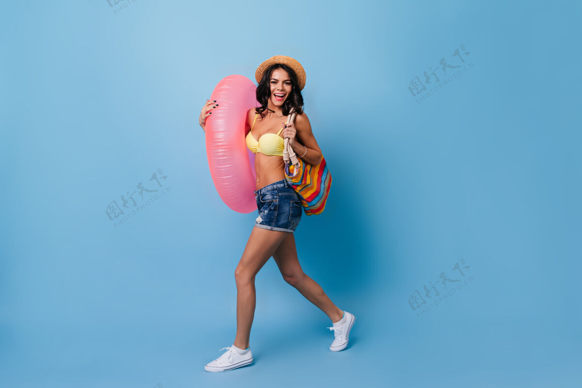 女士在蓝色背景上跳游泳圈的幸福女人搞笑时尚快乐