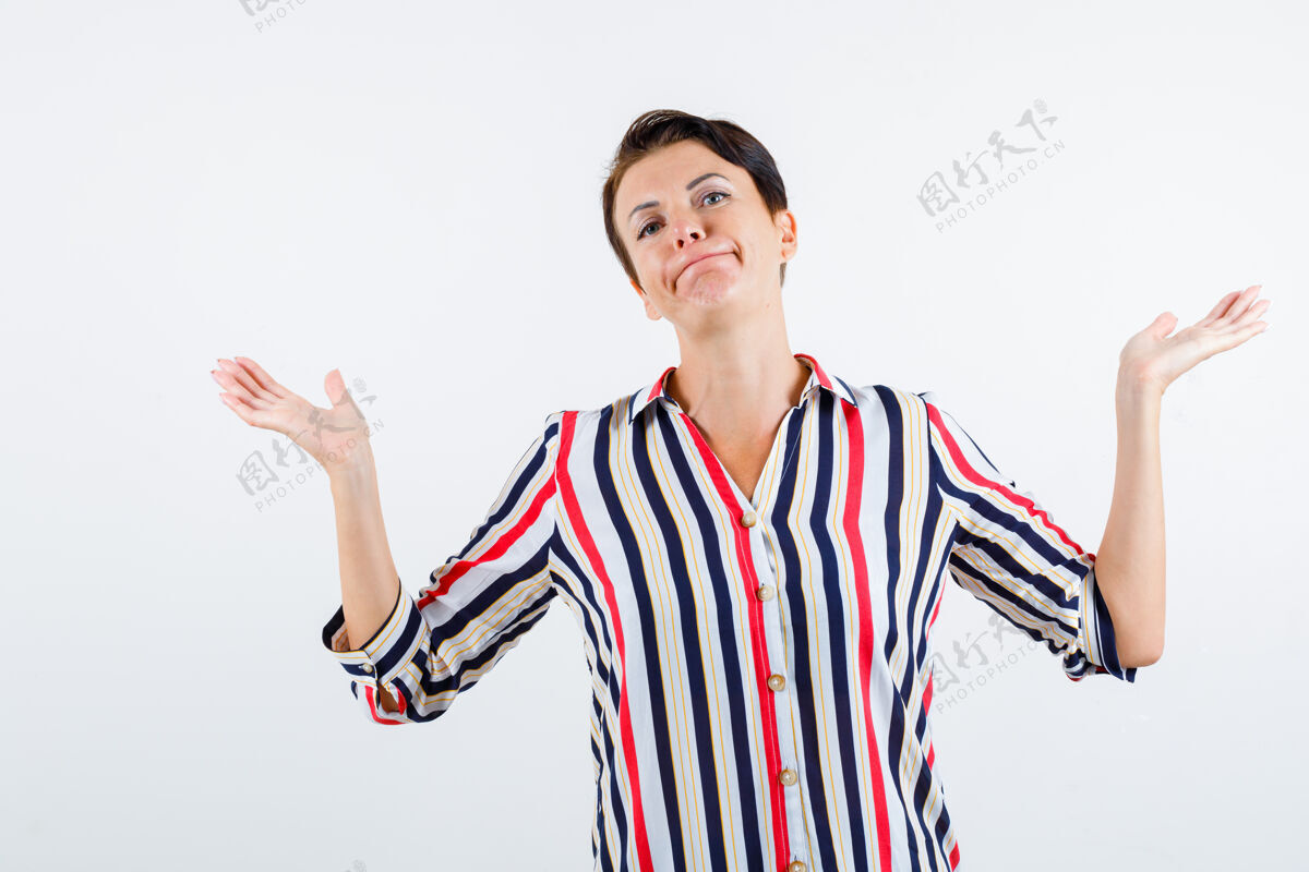 手势成熟的女人在条纹衬衫里表现出无助的姿态 看起来无能为力 正面视图衬衫女人老年人