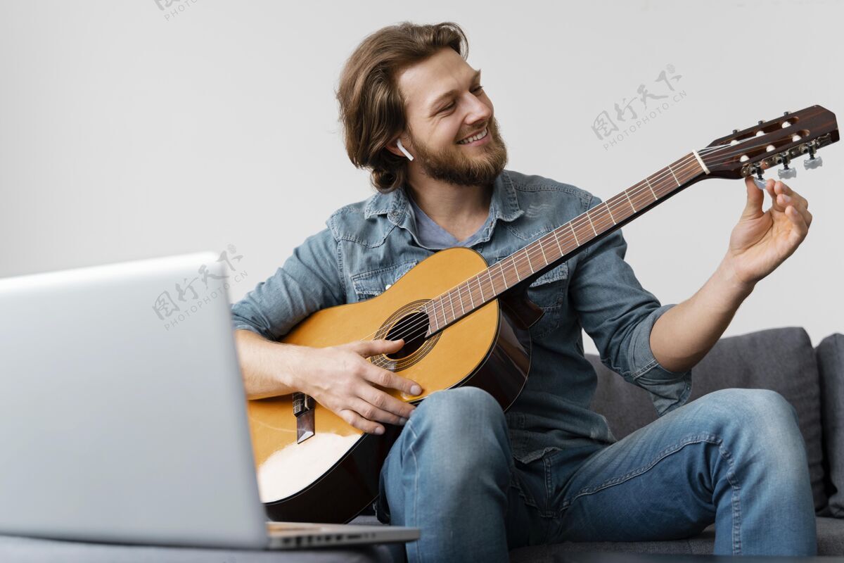 男人中枪笑脸吉他手在家里音乐设备
