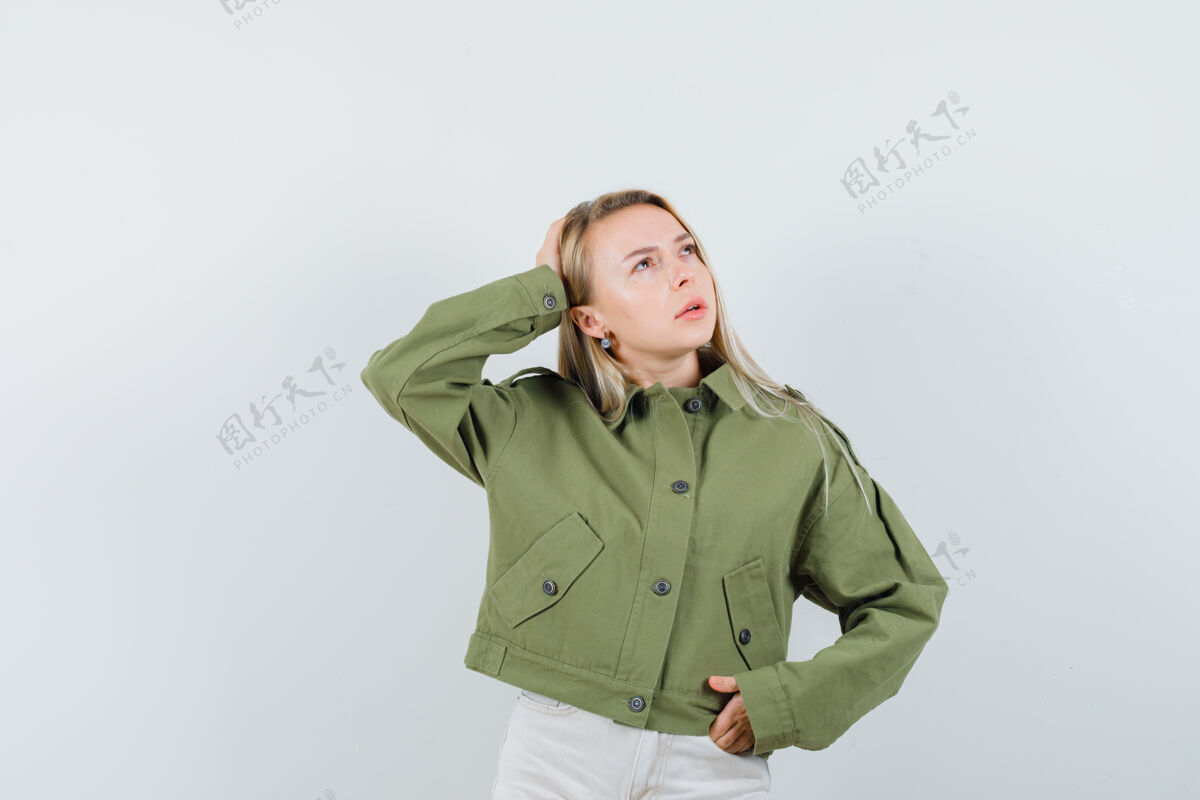 牛仔裤年轻女性手挽手 头戴绿色夹克 牛仔裤 神情专注 俯瞰前方人焦点夹克