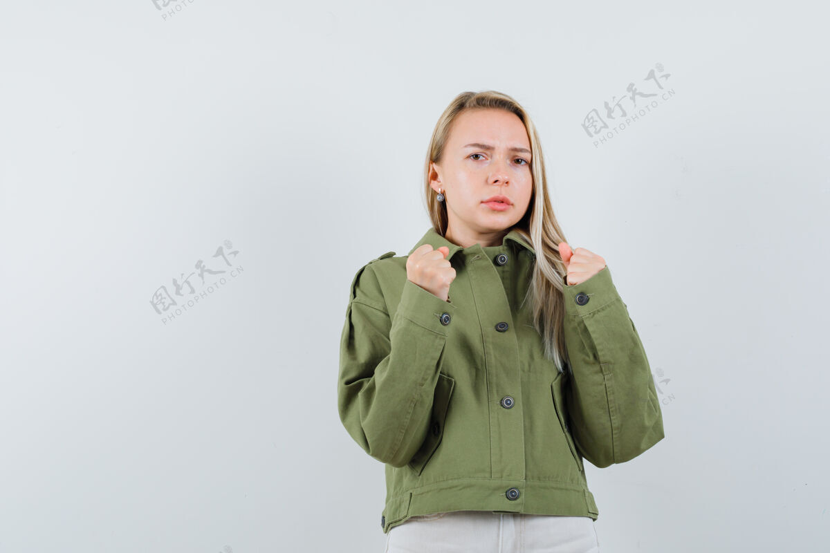 女孩金发女士站在拳击姿势在夹克 裤子和看起来恶意 前视图怨恨漂亮成人