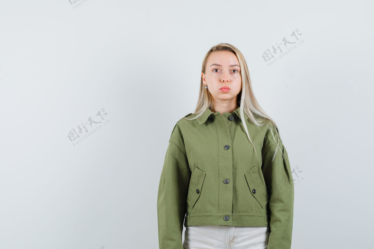 冷静年轻的女性撅着嘴 穿着绿色夹克 看上去很平静 正面照年轻女孩健康