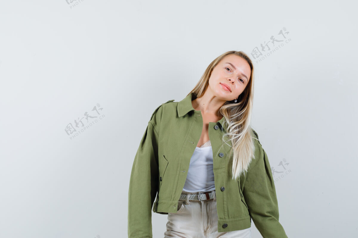 女孩年轻的女士站在夹克 裤子和看起来迷人的姿势前视图姿势年轻裤子