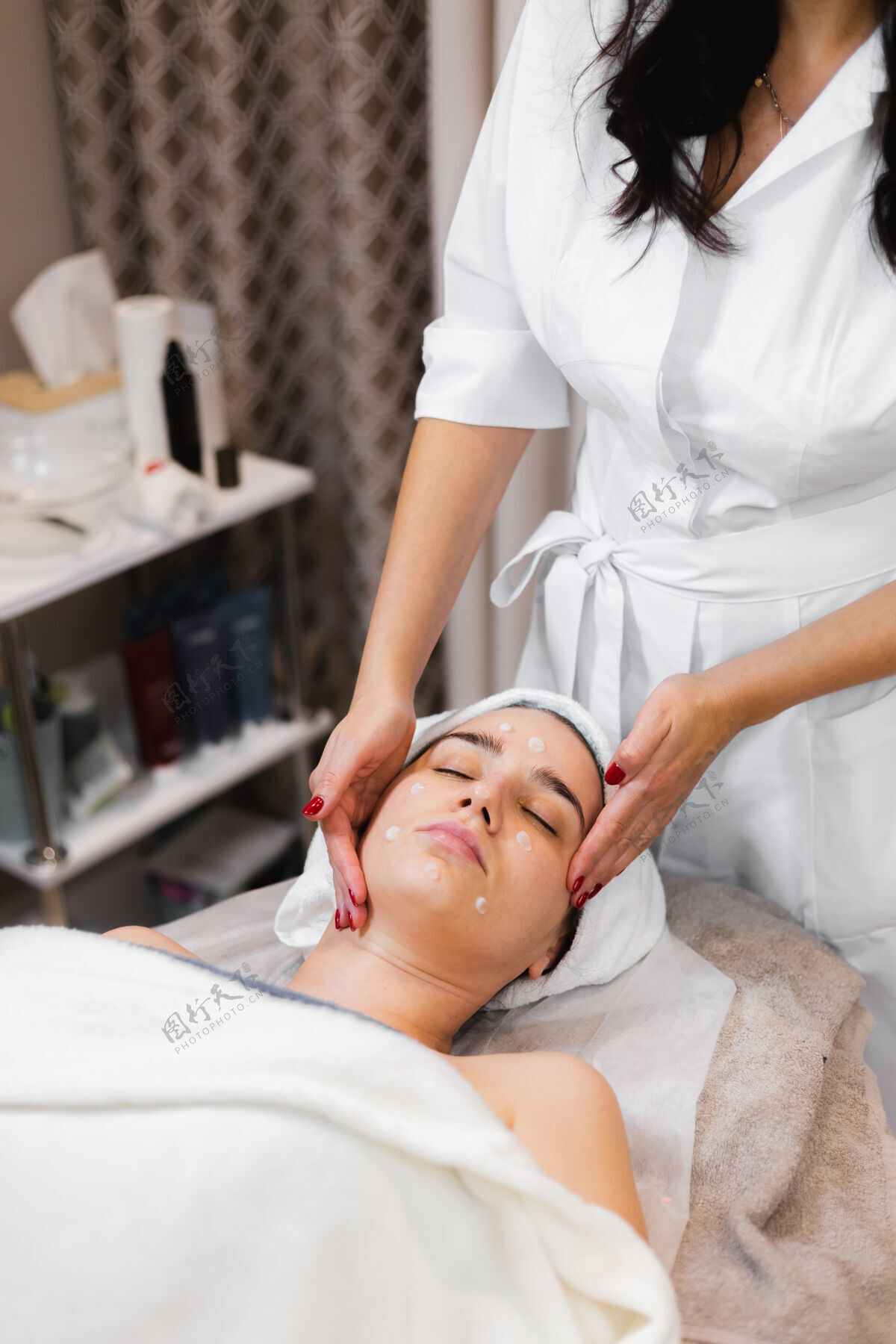 手美容师在美容院做手工面部按摩的女顾客治疗成人面部