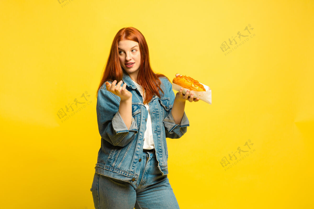 工作更容易成为追随者不需要和食物合影黄色背景的白种女人漂亮的红发模特人类情感的概念 面部表情 销售 广告手公司衬衫
