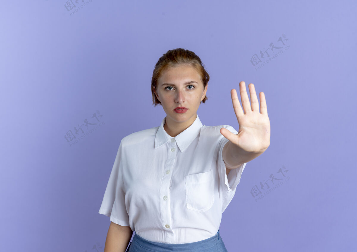 金发的年轻自信的金发俄罗斯女孩手势停止手标志孤立的紫色背景与复制空间年轻的停下手势
