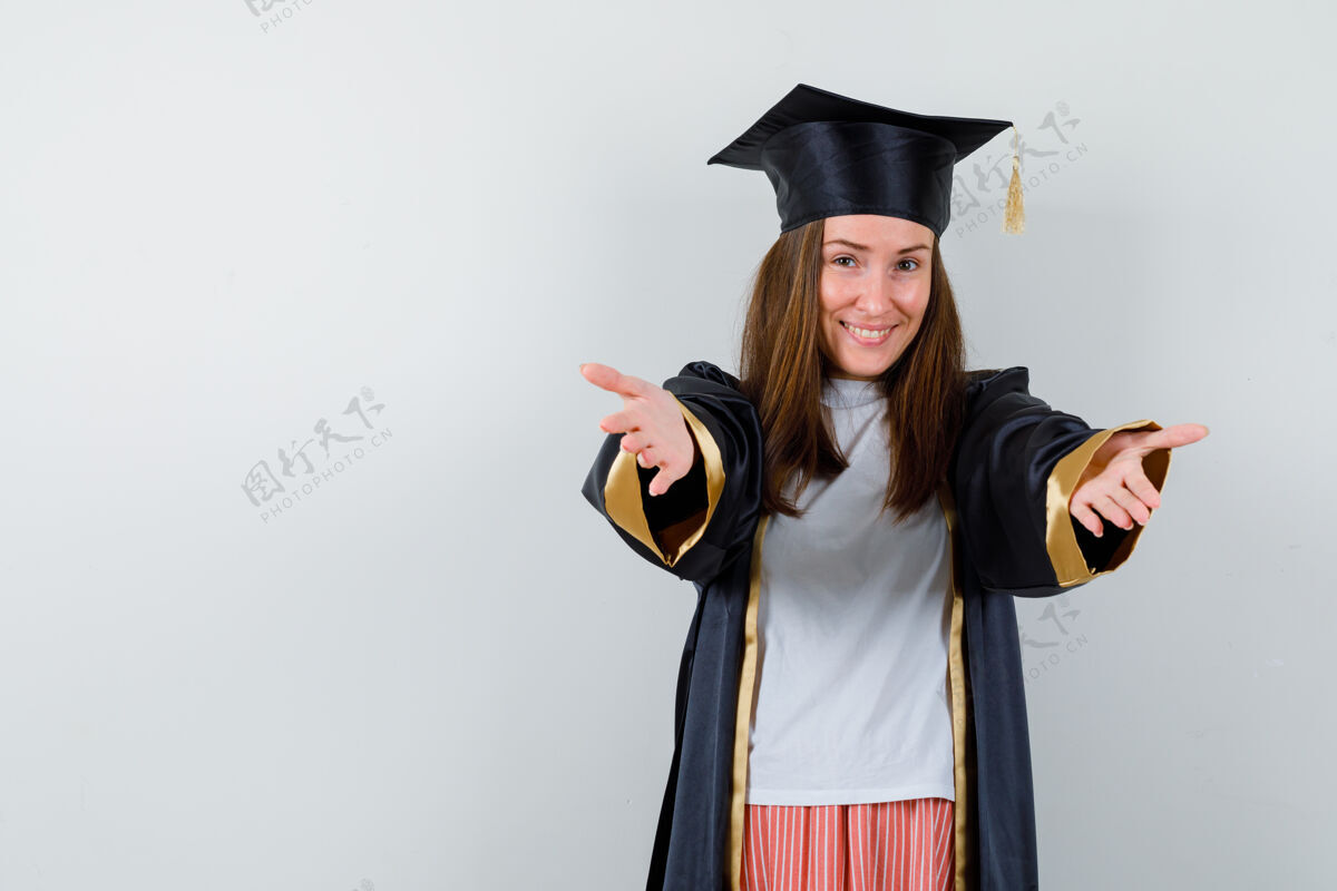 年轻毕业妇女的肖像张开双臂拥抱在休闲服 制服和期待愉快的前视图成就拥抱教育