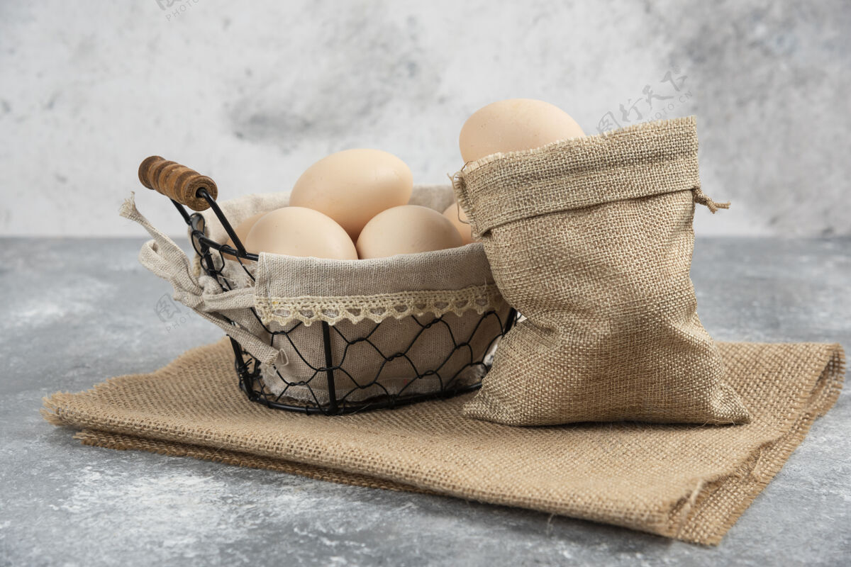美味篮子和麻布有机新鲜生鸡蛋放在大理石表面鸡鸟鸡蛋