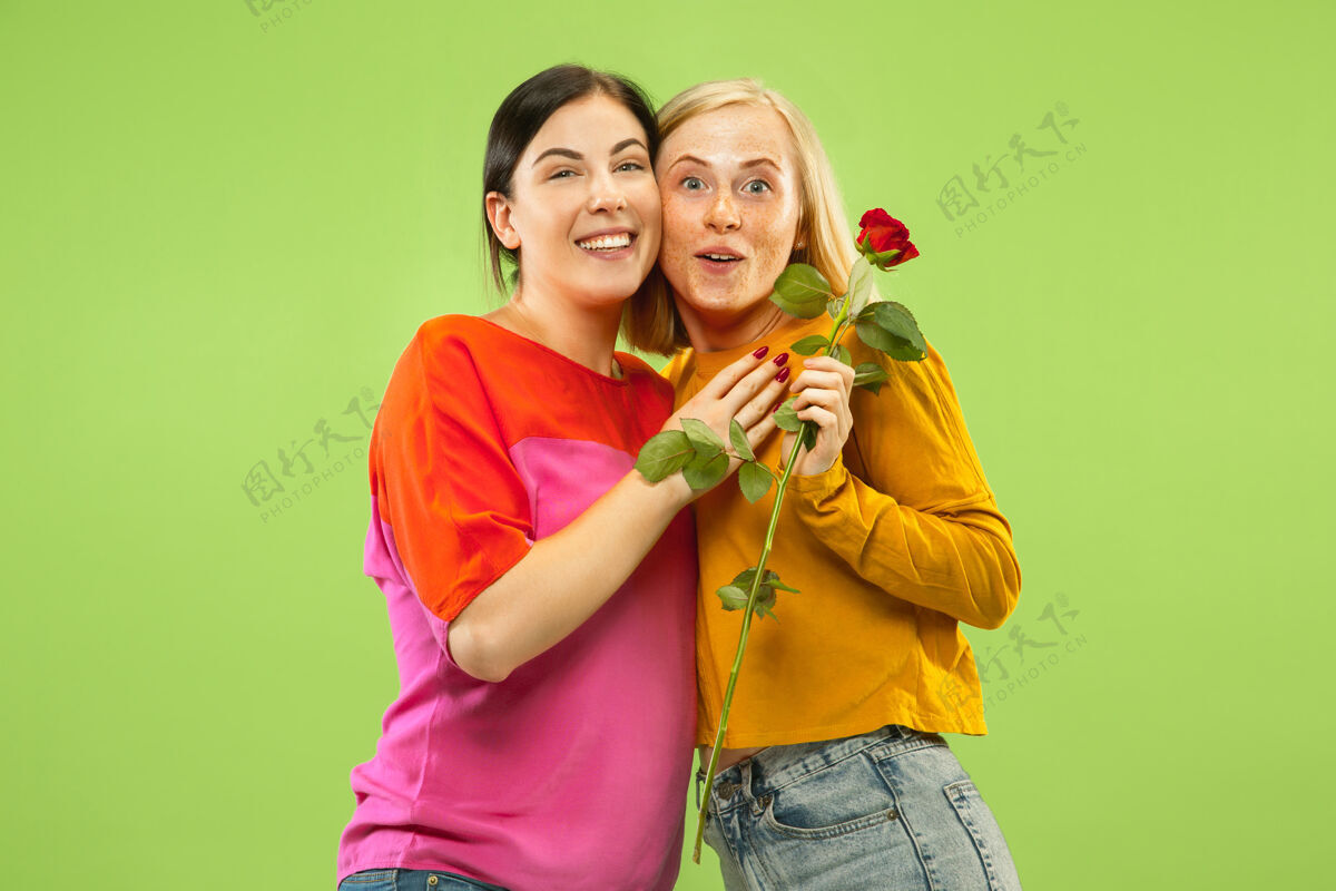 制造在绿色工作室背景上 穿着休闲服装的漂亮迷人女孩的肖像两个女模特作为女朋友或女同性恋lgbt的概念 平等 人类情感 爱情 关系关系长女性