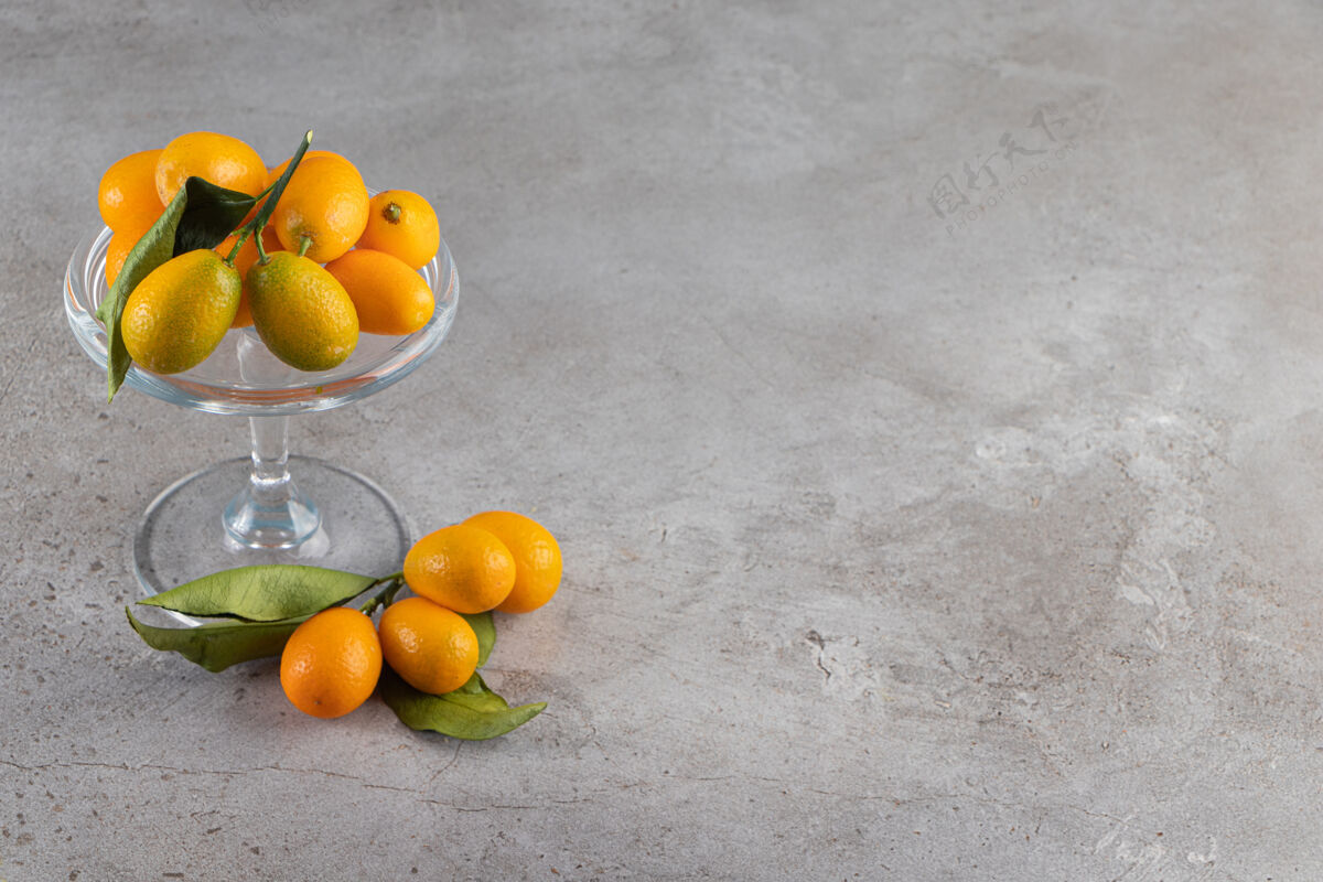 营养在石头背景上放上一盘新鲜多汁的金橘小吃新鲜健康