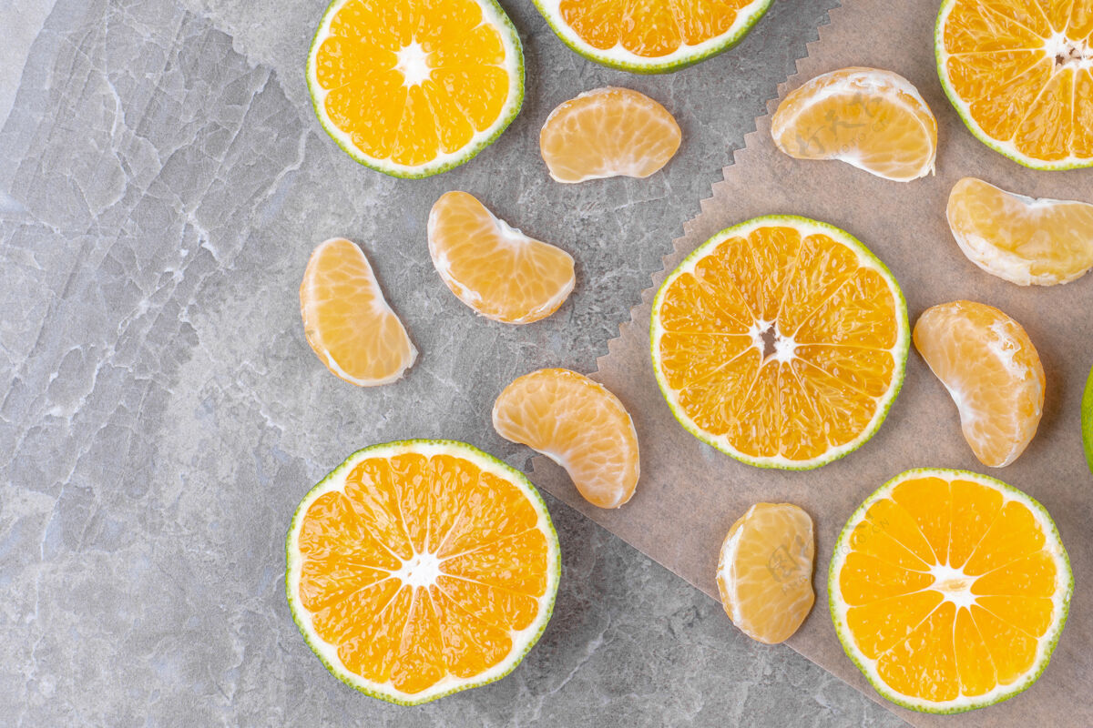 新鲜橘子片和新鲜柠檬片放在大理石表面水果小吃果皮