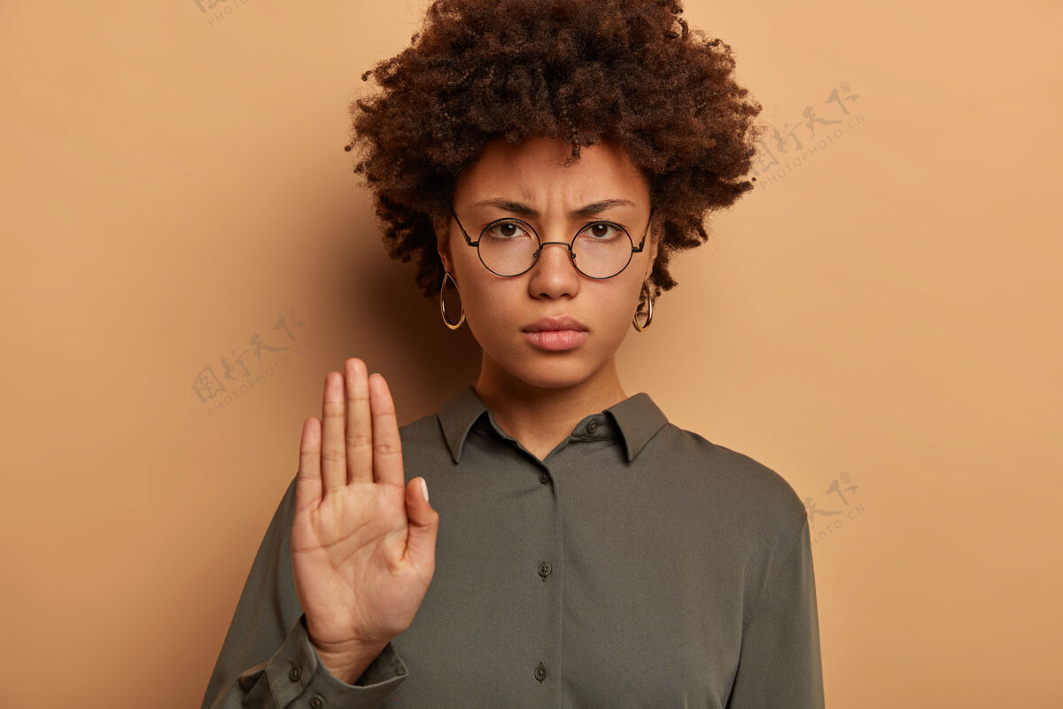 非洲专横严肃的女人看着镜头 伸出手掌 表示忌讳或禁止 皱眉的脸不高兴拒绝手势