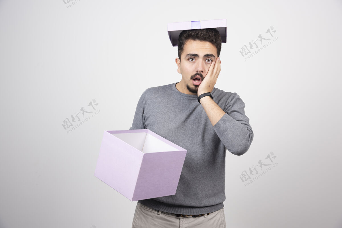 男人一个手拿紫色盒子的令人震惊的男人模特男人礼物
