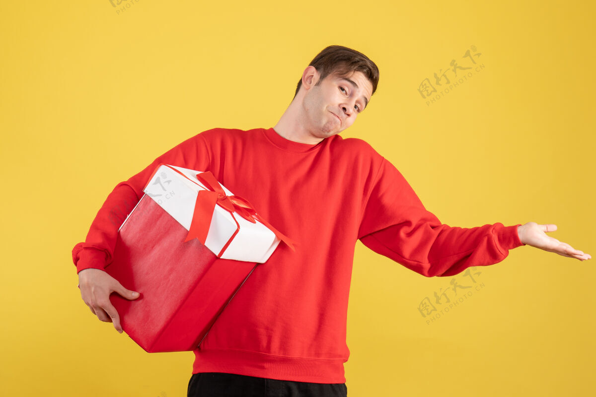 肖像前视图穿着红色毛衣的年轻人在黄色背景上张开他的手成人快乐背景