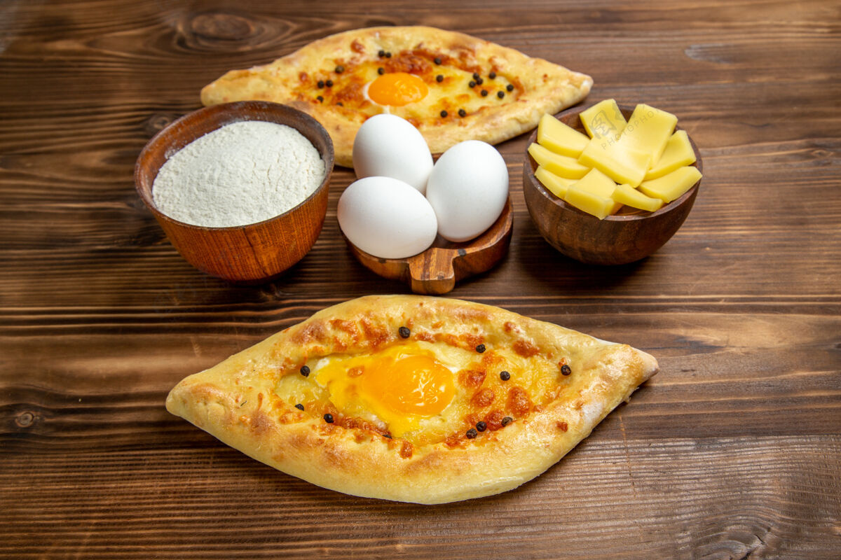 顶部顶视图烤鸡蛋面包从棕色木制书桌上的烤箱新鲜的面团鸡蛋面包早餐面包膳食晚餐奶酪