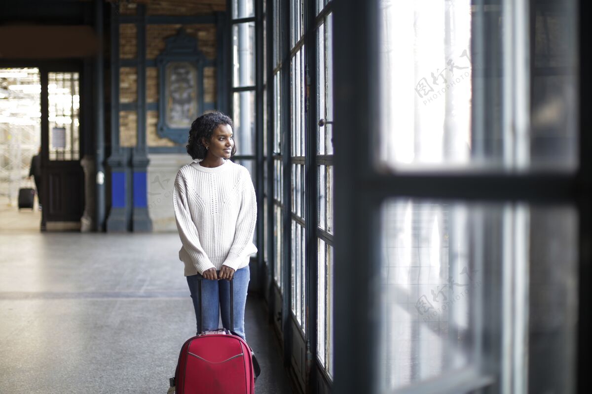 漂亮美丽的镜头 一个女性在白色长袖红色行李 而看着一个窗口行李旅行手提箱