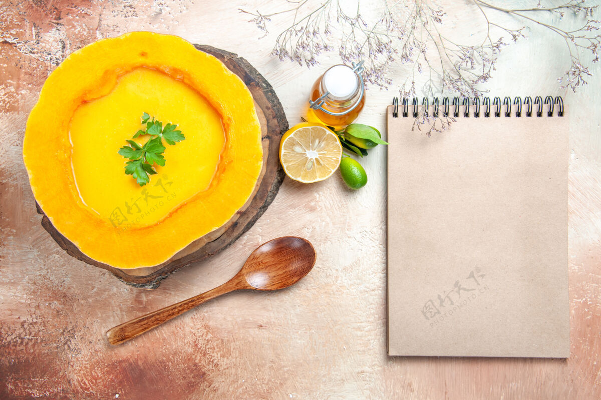 冬南瓜顶部特写查看一个汤南瓜汤与草药板勺子油柠檬奶油笔记本顶部食物美食
