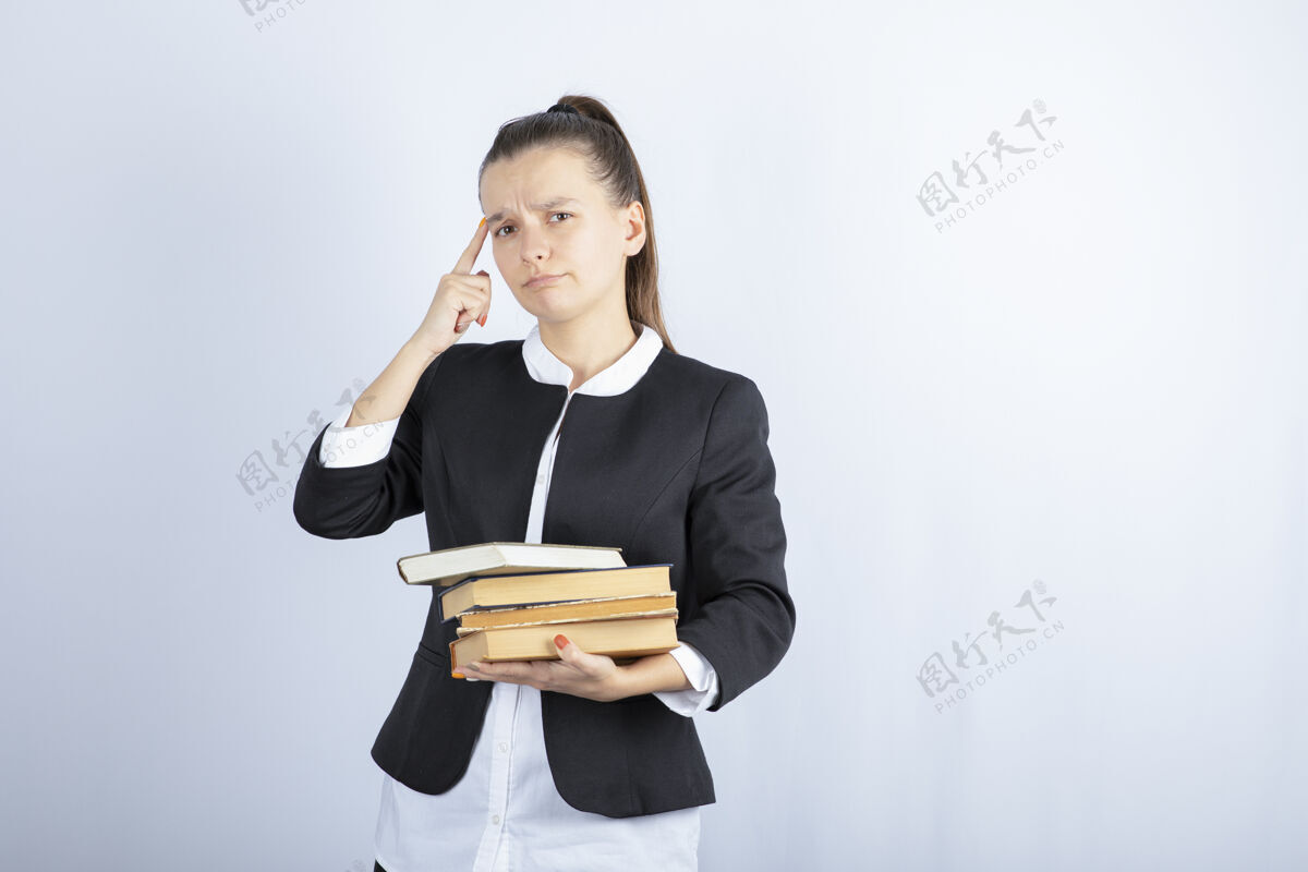 女士一个年轻学生拿着一堆书思考白色的画面年轻个人聪明