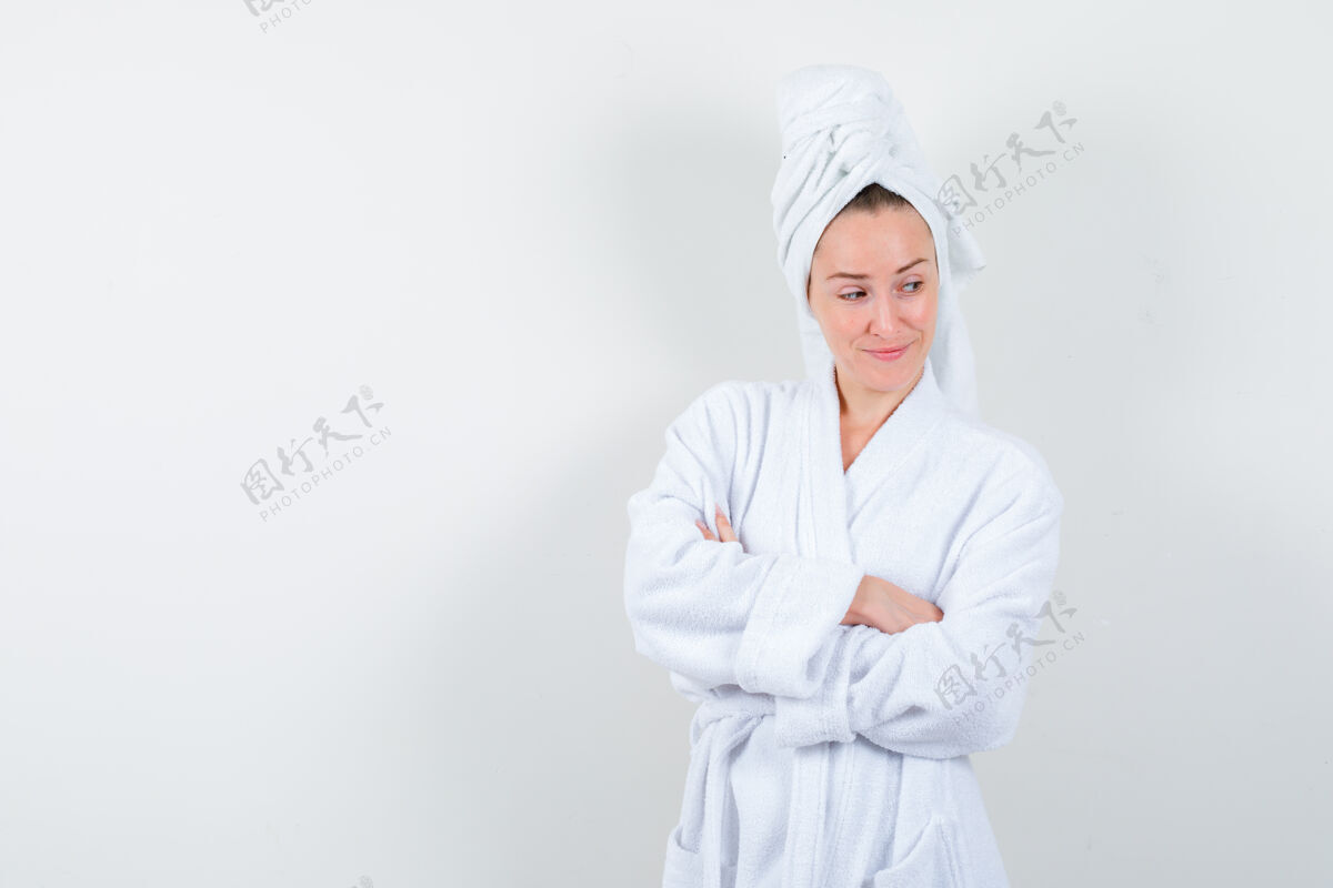 时尚身穿白色浴袍 手交叉毛巾的年轻女子 面带沉思地站在前面站立肖像年轻