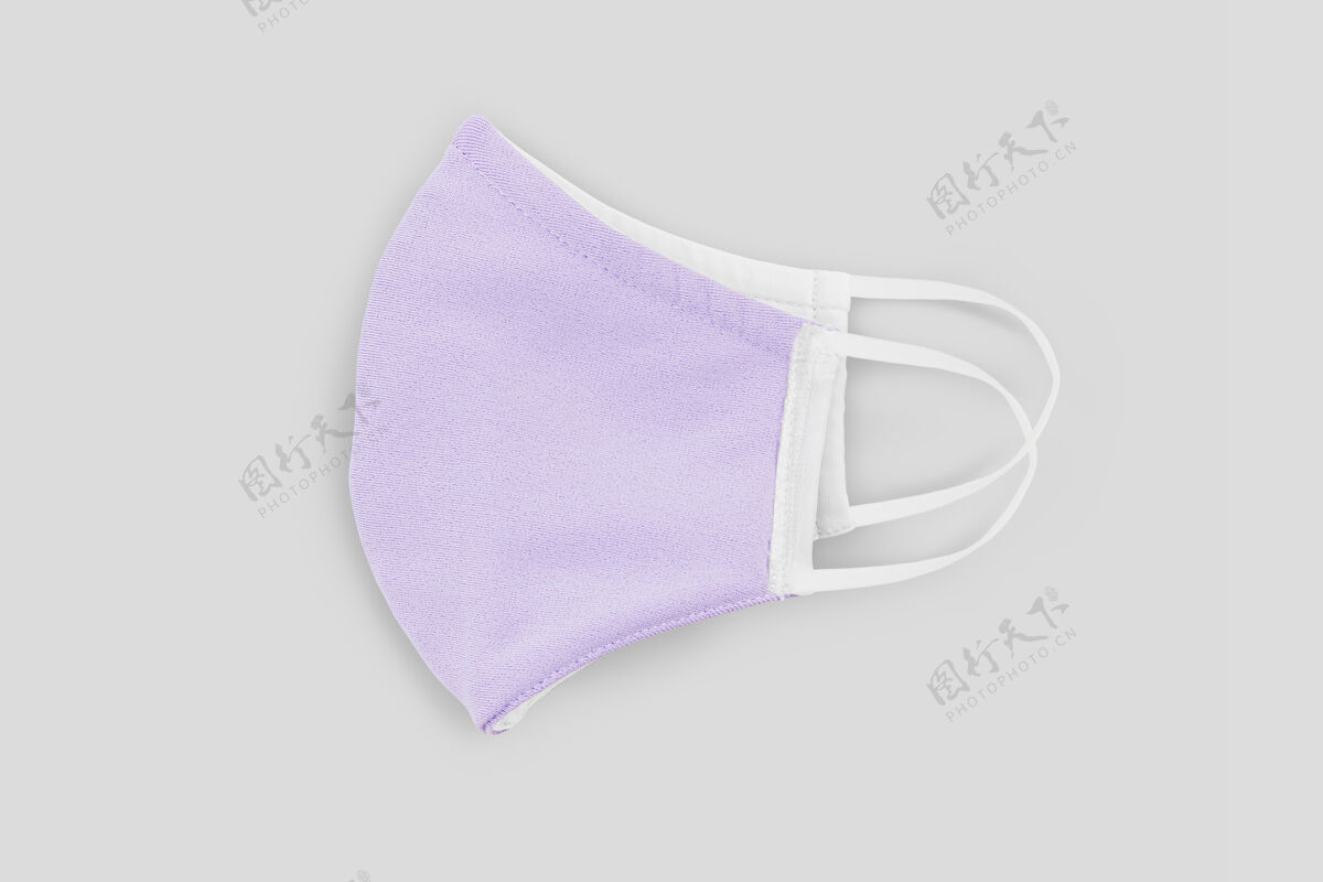 布口罩粉彩紫色织物面膜的灰色背景病毒传播空气污染防护