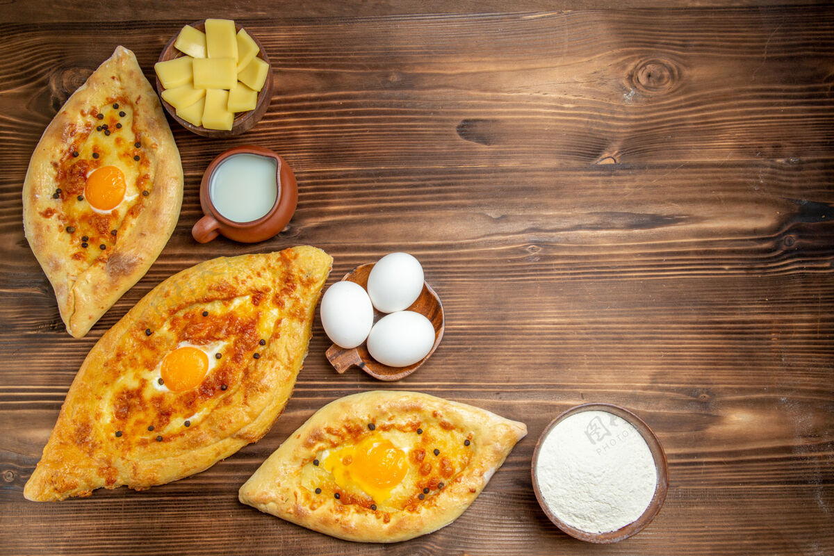 烘焙顶视图烤鸡蛋面包新鲜出炉的木制表面面团鸡蛋面包早餐面包美食膳食景观