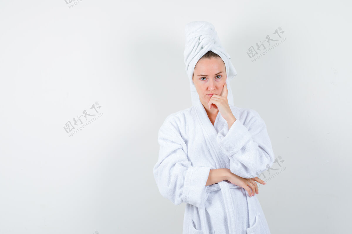 节日身穿白色浴袍的年轻女子 手上拿着毛巾托着下巴 看上去很懂事 正前方的景色女人卷发显示