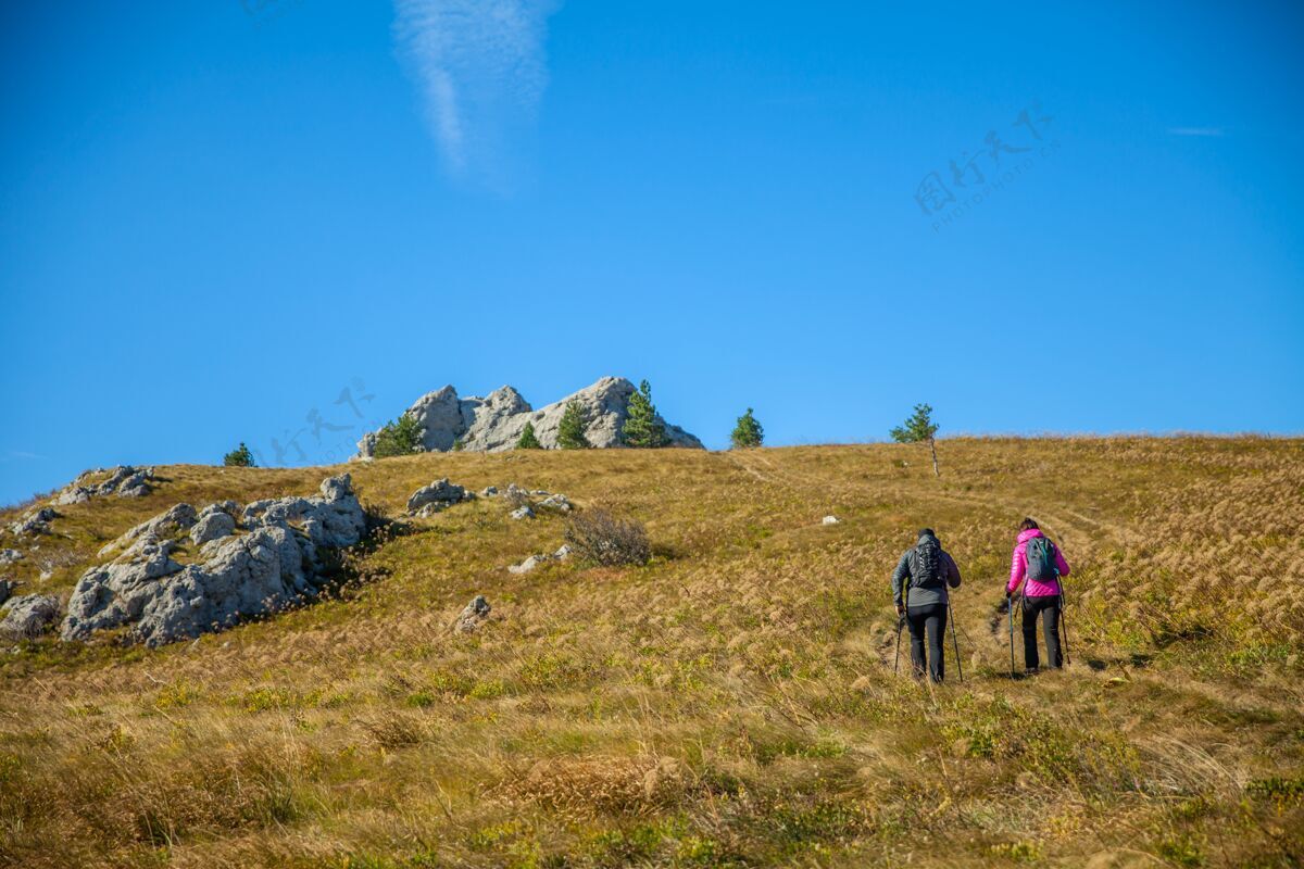男人可爱的旅游情侣在蓝天下攀登斯洛文尼亚落基山脉冒险徒步旅行生活方式