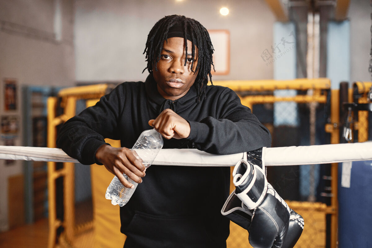 力量运动型男子拳击拳击手在拳击场上的照片非裔美国人拿着一瓶水男性健身戒指