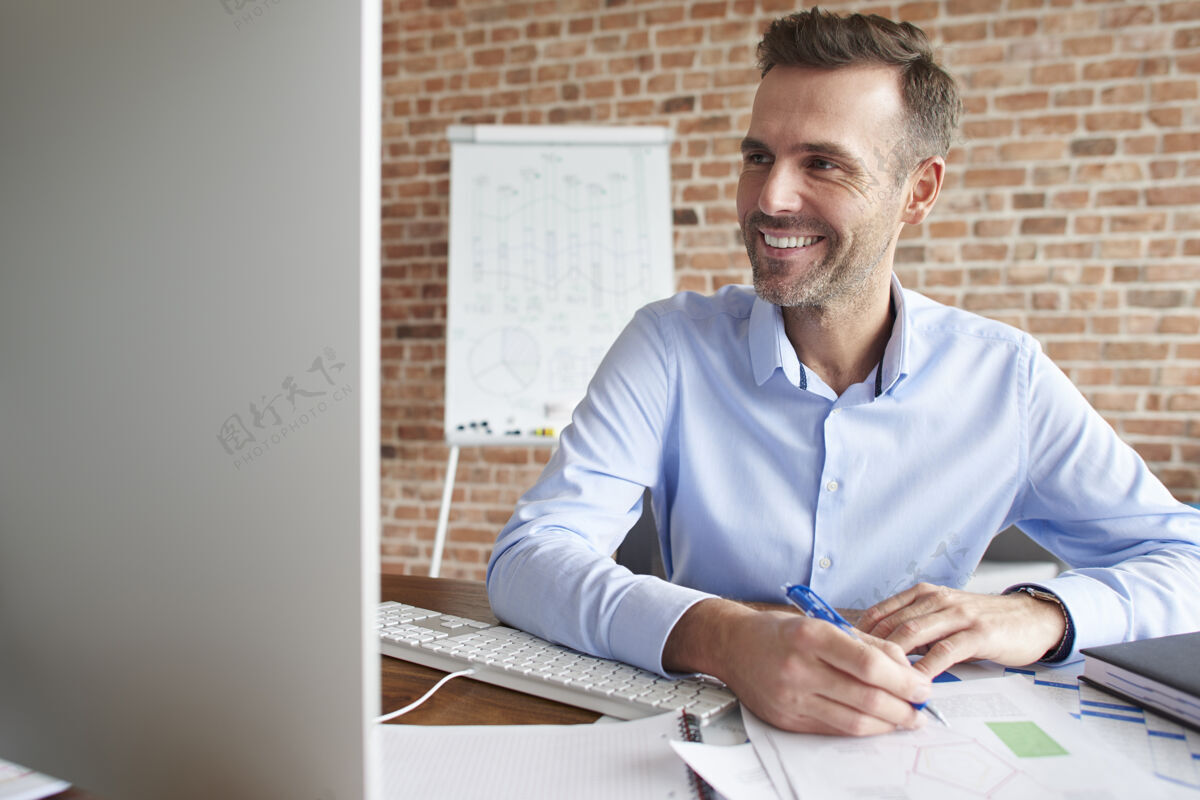 微笑男人在电脑上工作时注意力集中生意人现代人生意人