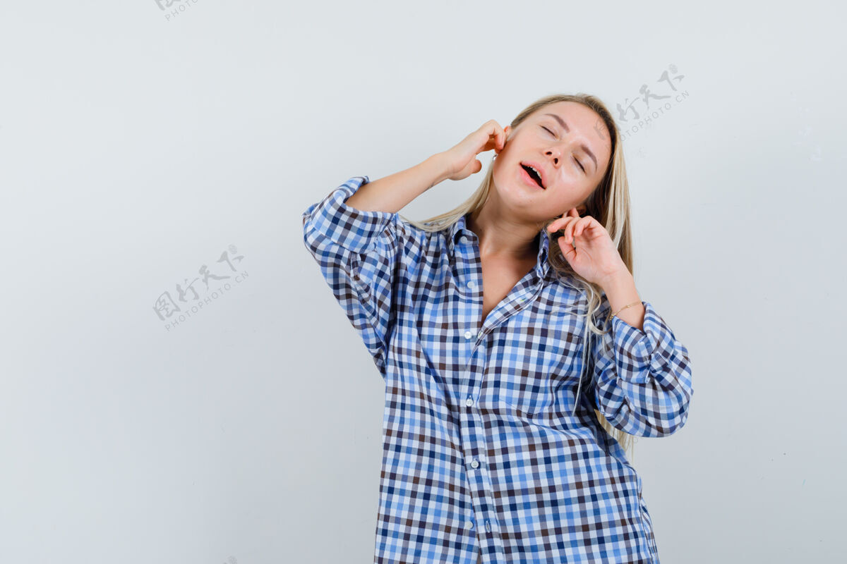 金发金发女郎穿着休闲衬衫假装在听音乐 看起来很高兴音乐健康衬衫