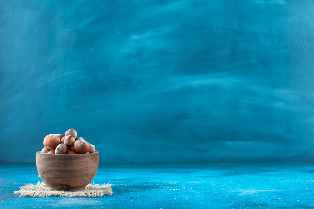 美味榛子在碗里的纹理上呈蓝色表面蛋白质健康美味