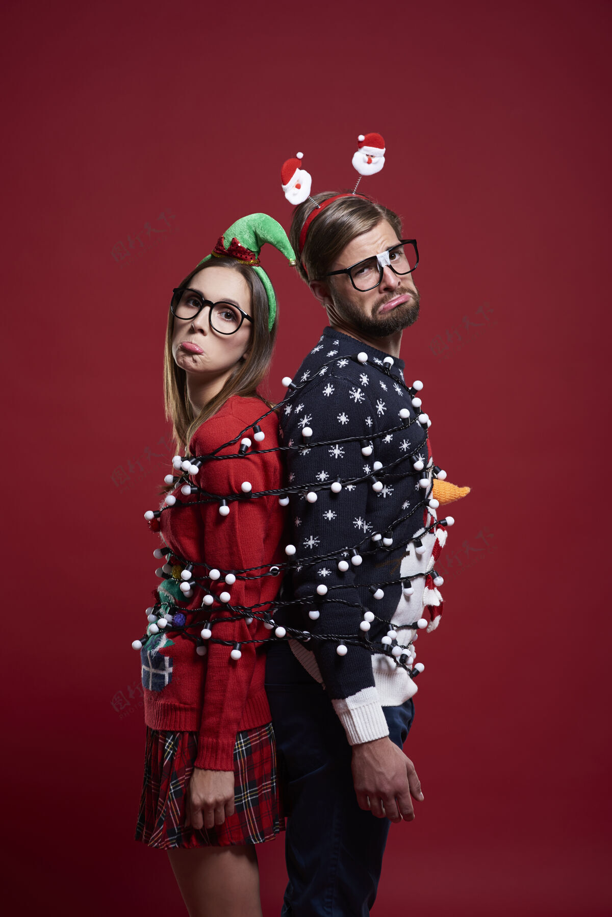 圣诞节笨手笨脚的夫妇对圣诞灯有问题时尚情侣悲伤