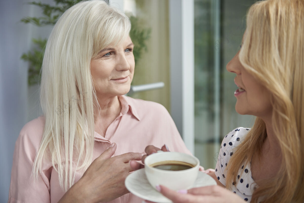 退休特写成年女性在阳台上享受美味的咖啡老年女性休闲服咖啡
