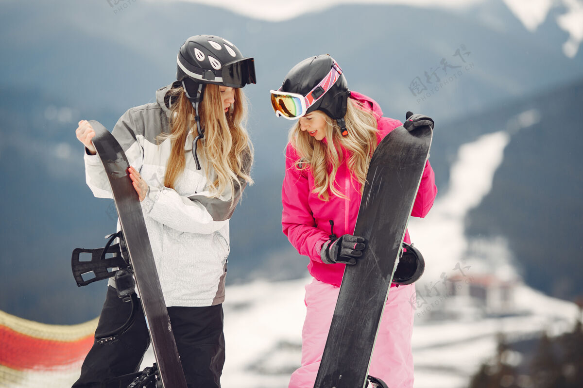 运动穿着滑雪板套装的女人在山上的运动员手拿滑雪板在地平线上关于运动的概念装备女性滑雪板