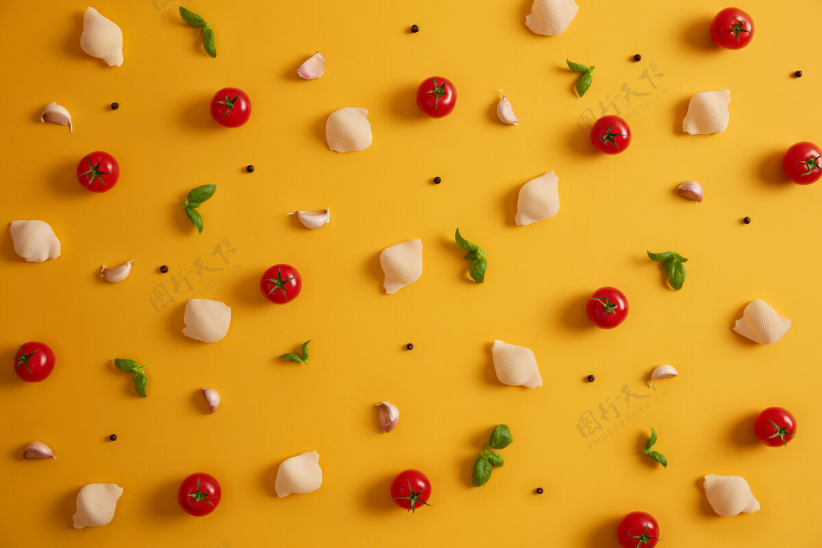 传统用硬粒小麦 红樱桃番茄 罗勒和大蒜制成的意大利面外壳的平面视图 用于准备意大利菜黄色背景上的蔬菜和香料烹饪配料排毒食品小麦观点配料