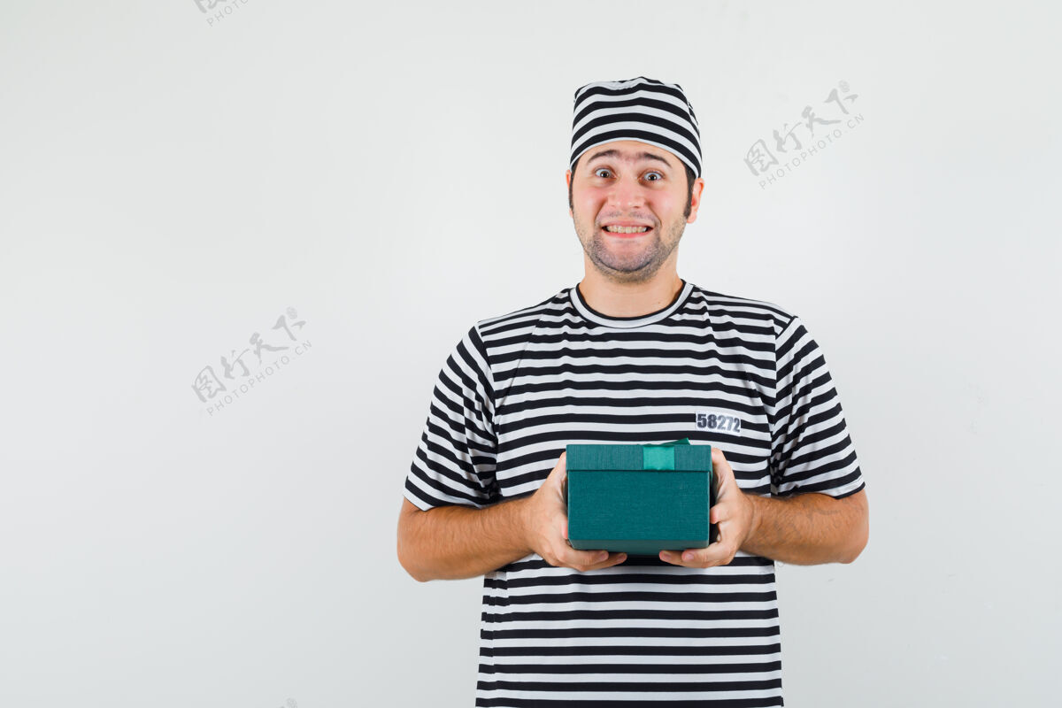 思想年轻的男士穿着t恤 戴着礼盒的帽子 看起来很快乐 正前方胡子持有前面