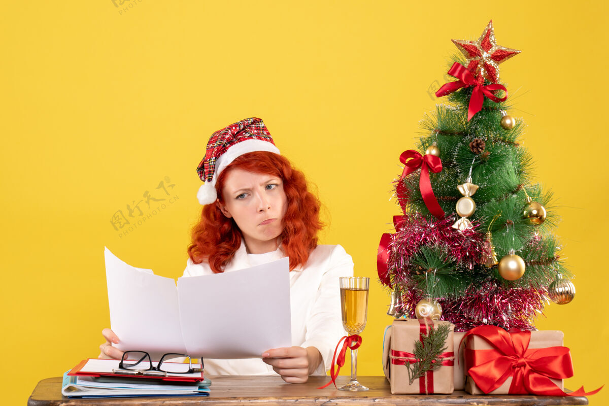 抱前视图：女医生在桌子后面拿着文件圣诞微笑健康