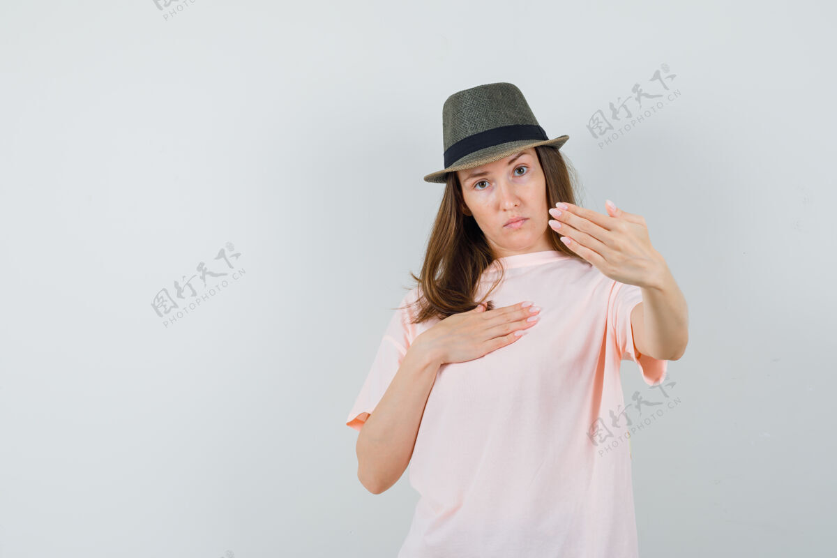 积极一位年轻的女士 戴着粉色的t恤帽子 表现出拒绝的姿态 看上去很坚决在一起T恤决议